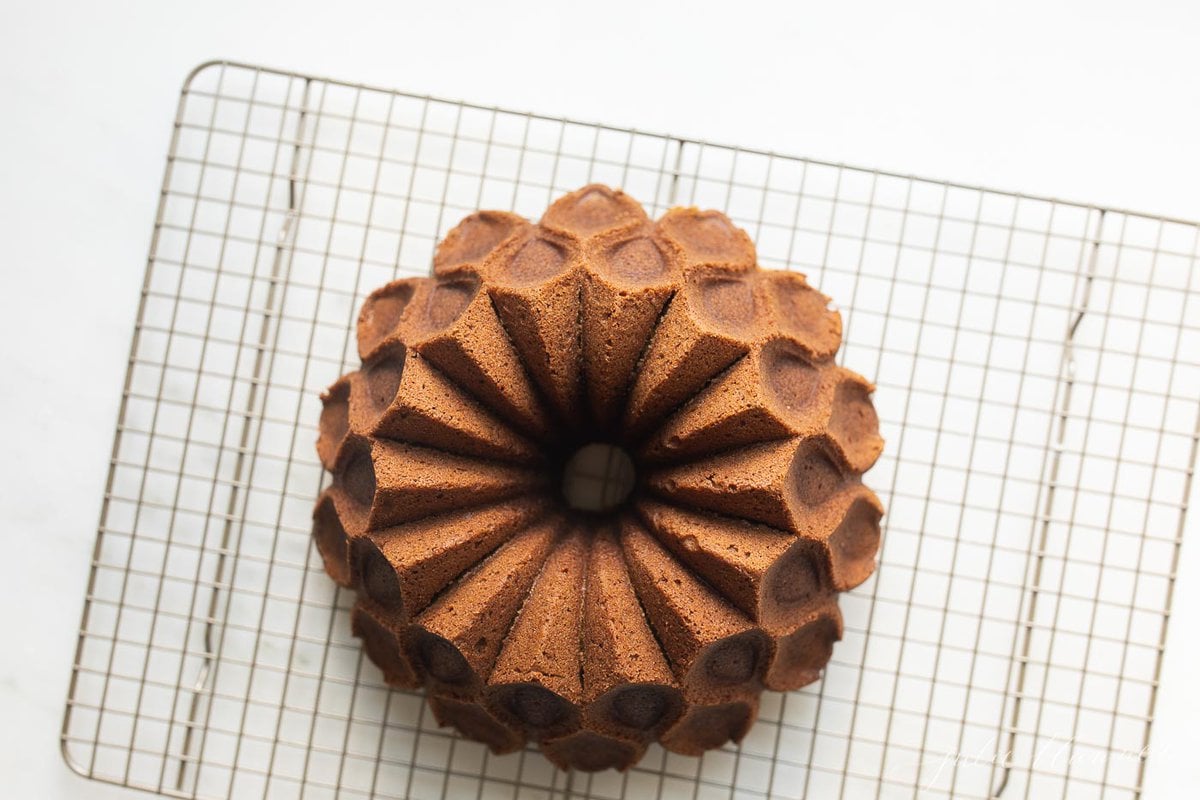 A pumpkin bundt cake on a wire cooling rack.