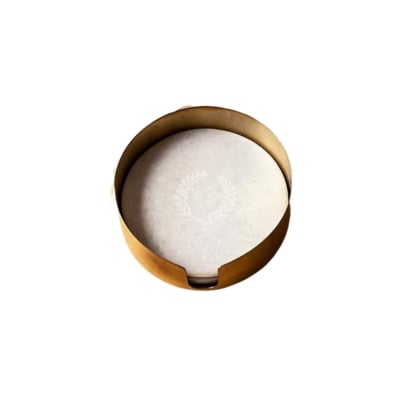 A gold coaster adorned with laurel wreaths on a white surface.