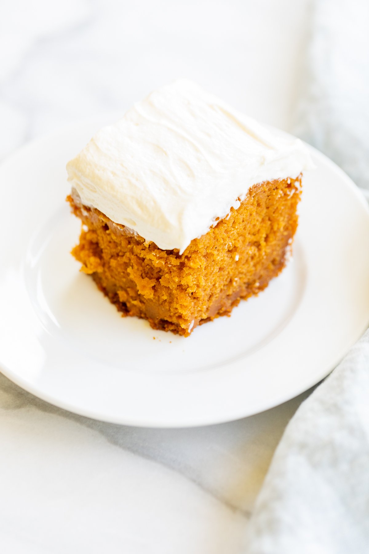 A slice of pumpkin cake on a white plate.