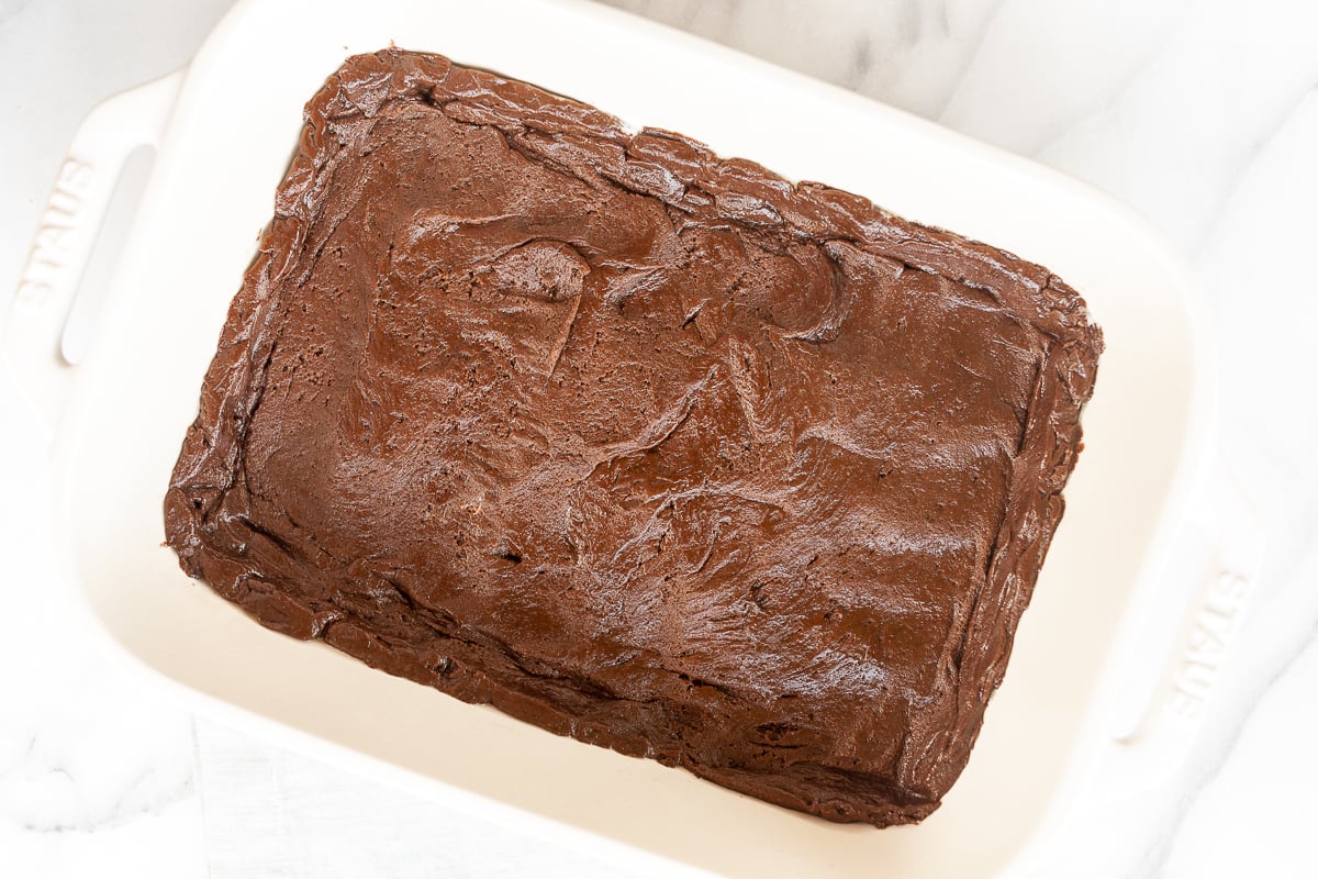 A peanut butter ooey gooey butter cake base in a white pan.