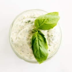 A small glass jar full of pesto aioli.