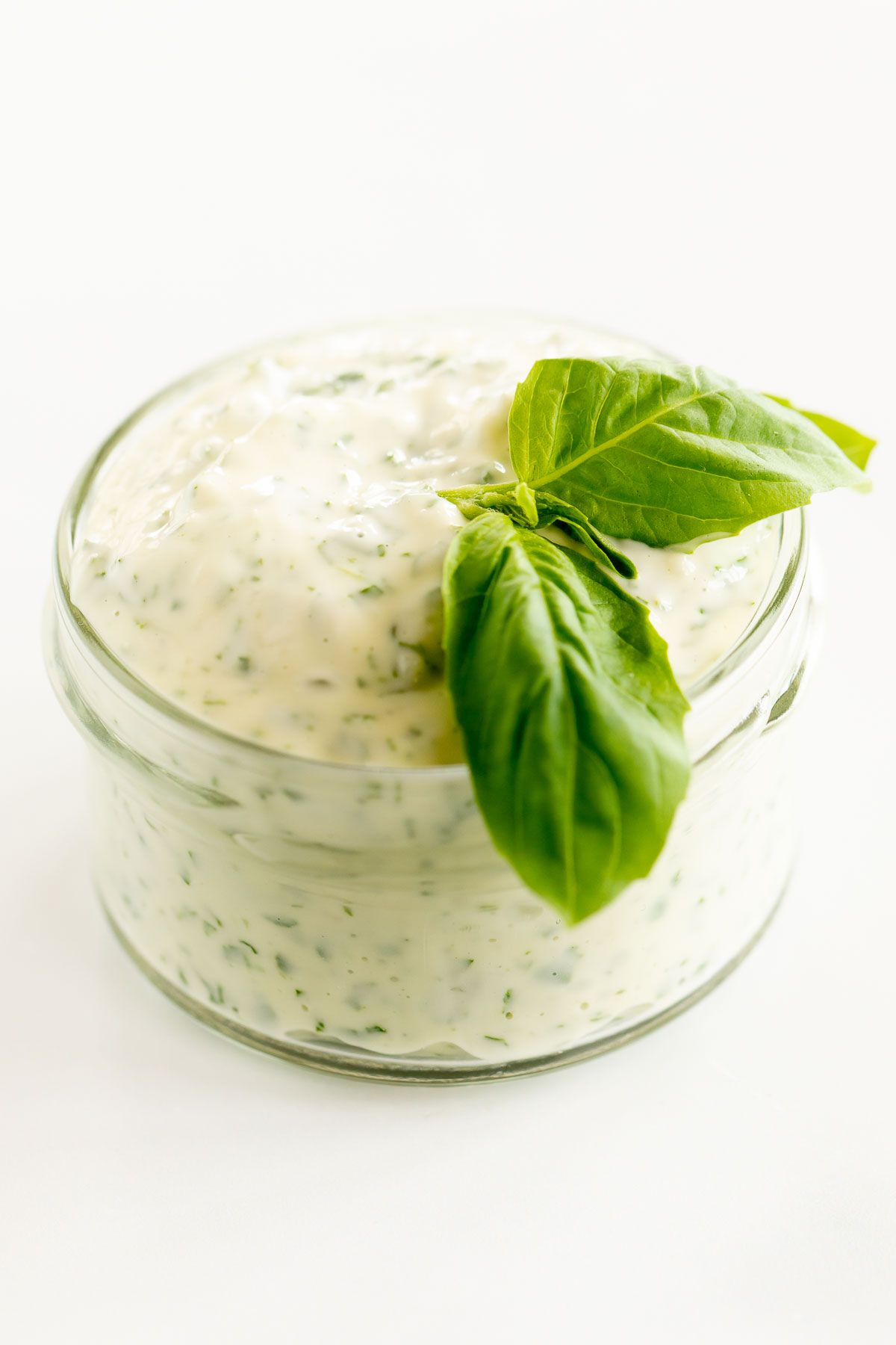 A small glass jar full of pesto aioli.