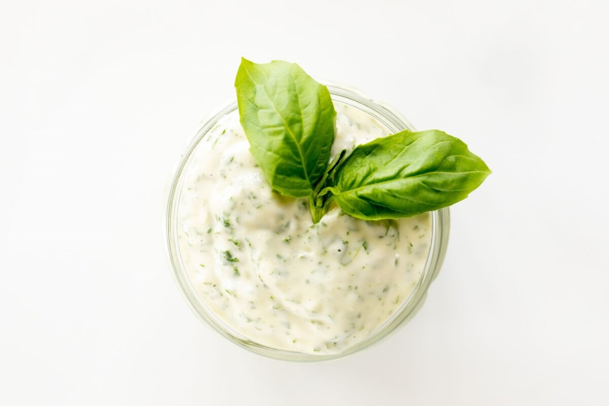 A small glass jar full of pesto aioli.