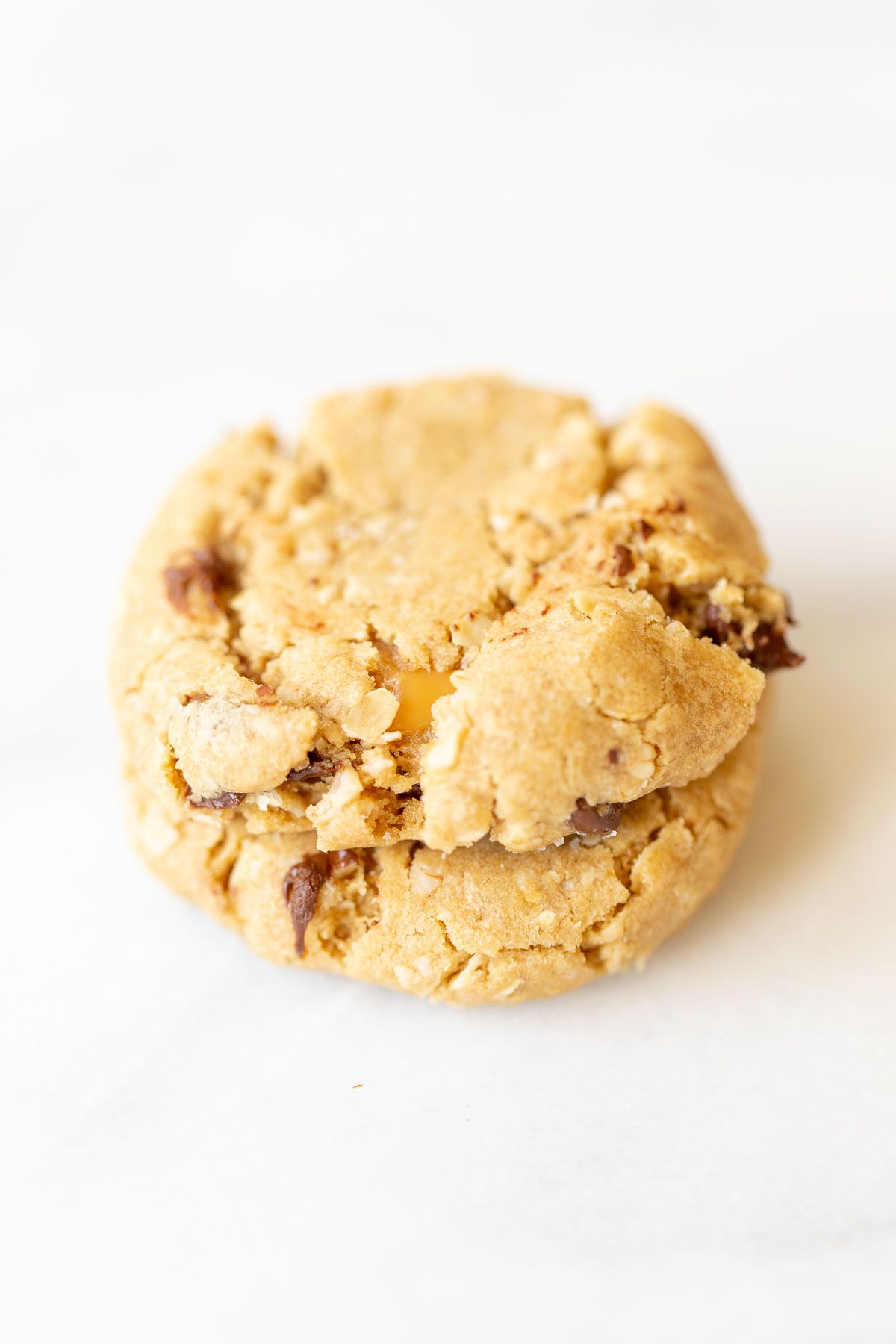 A stack of two carmelita cookies on a white marble surface.