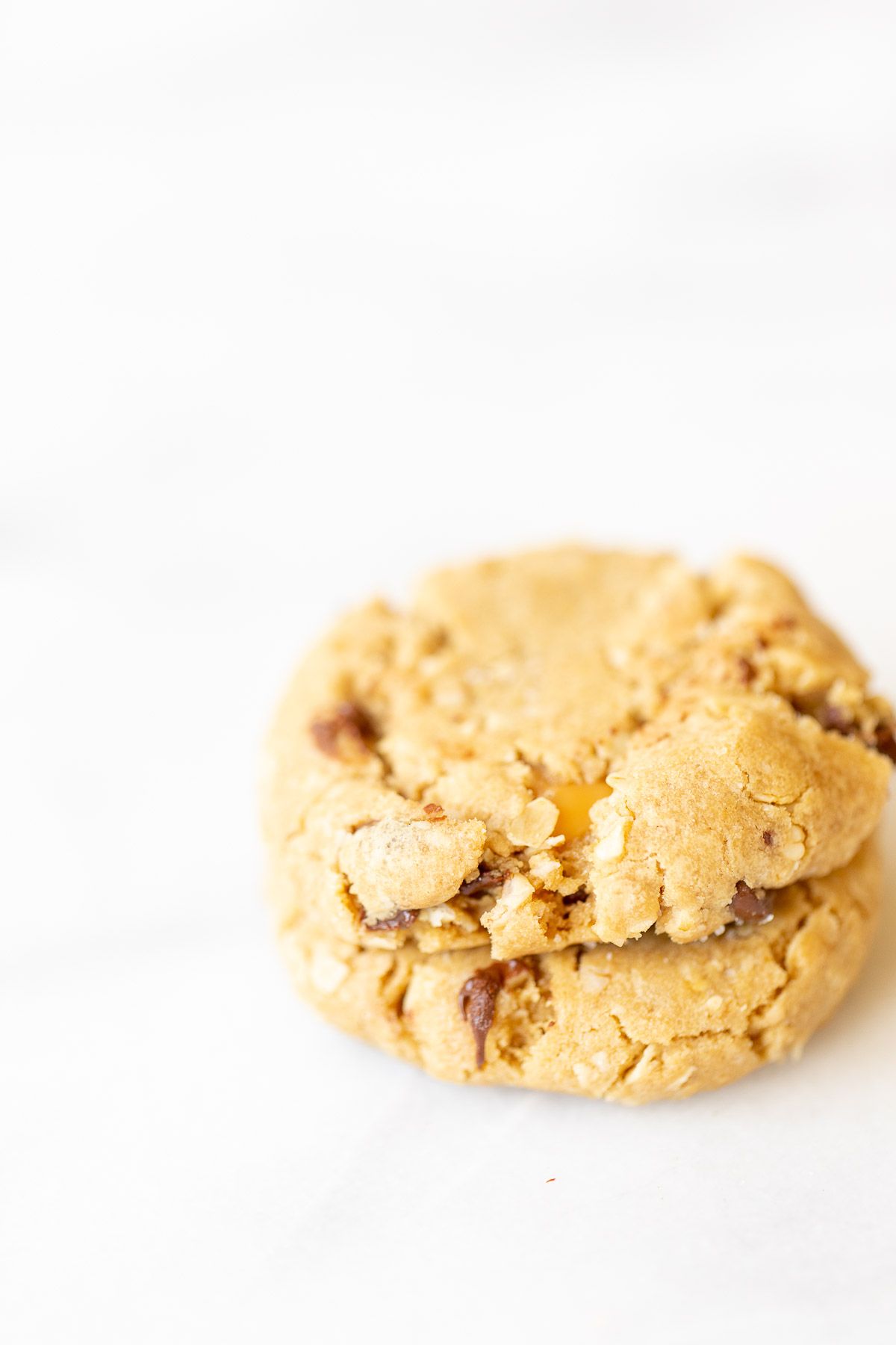 A stack of two carmelita cookies on a white marble surface.