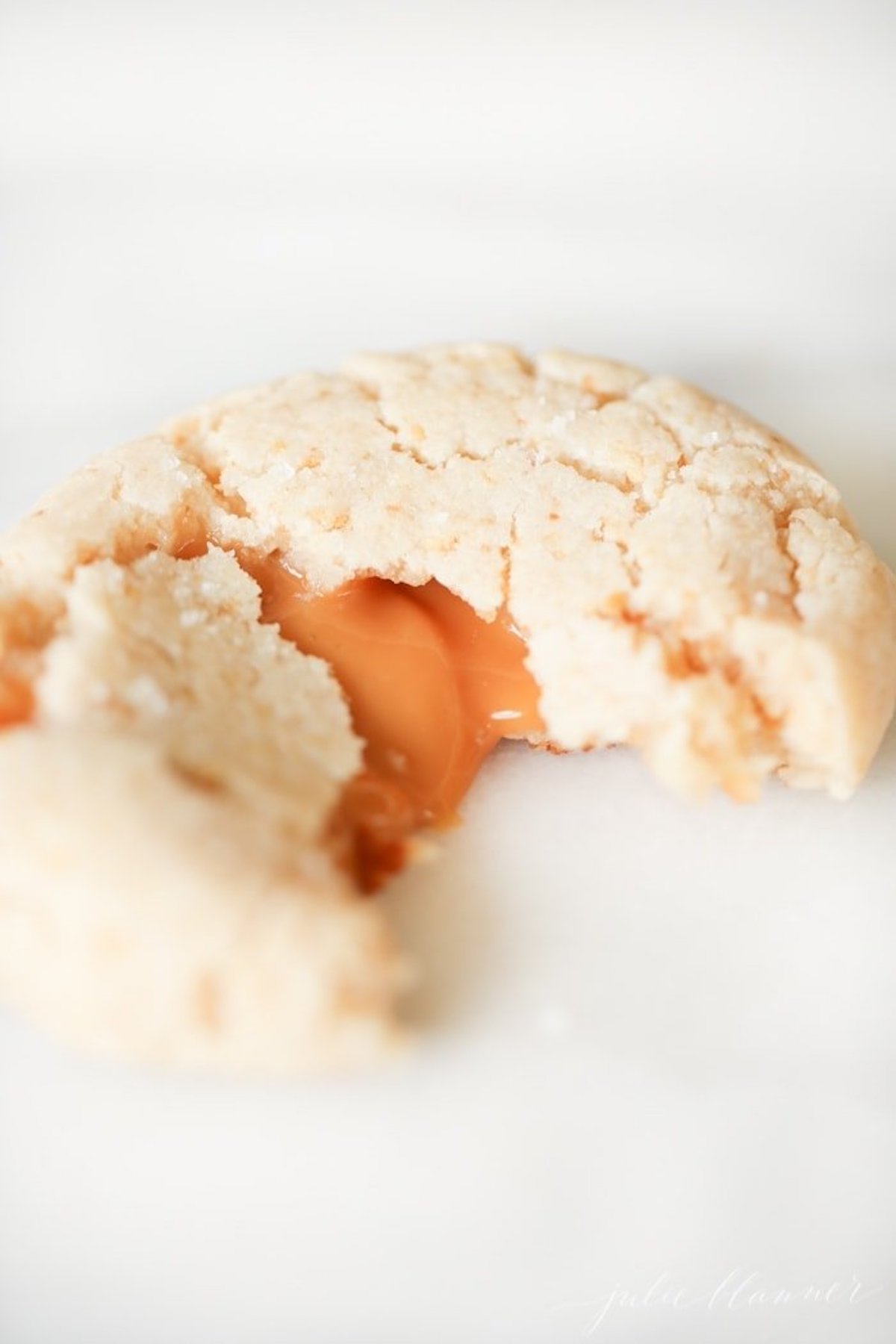 A caramel cheesecake cookie with a bite out of one side.