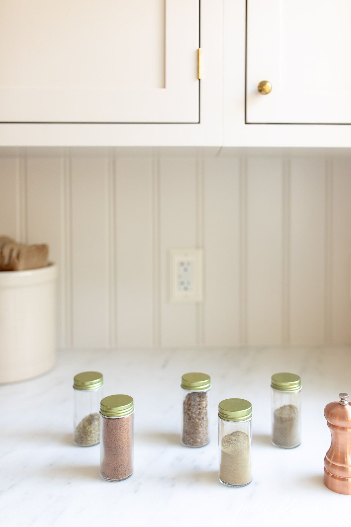 Spices for chicken seasoning in clear glass jars with gold lids