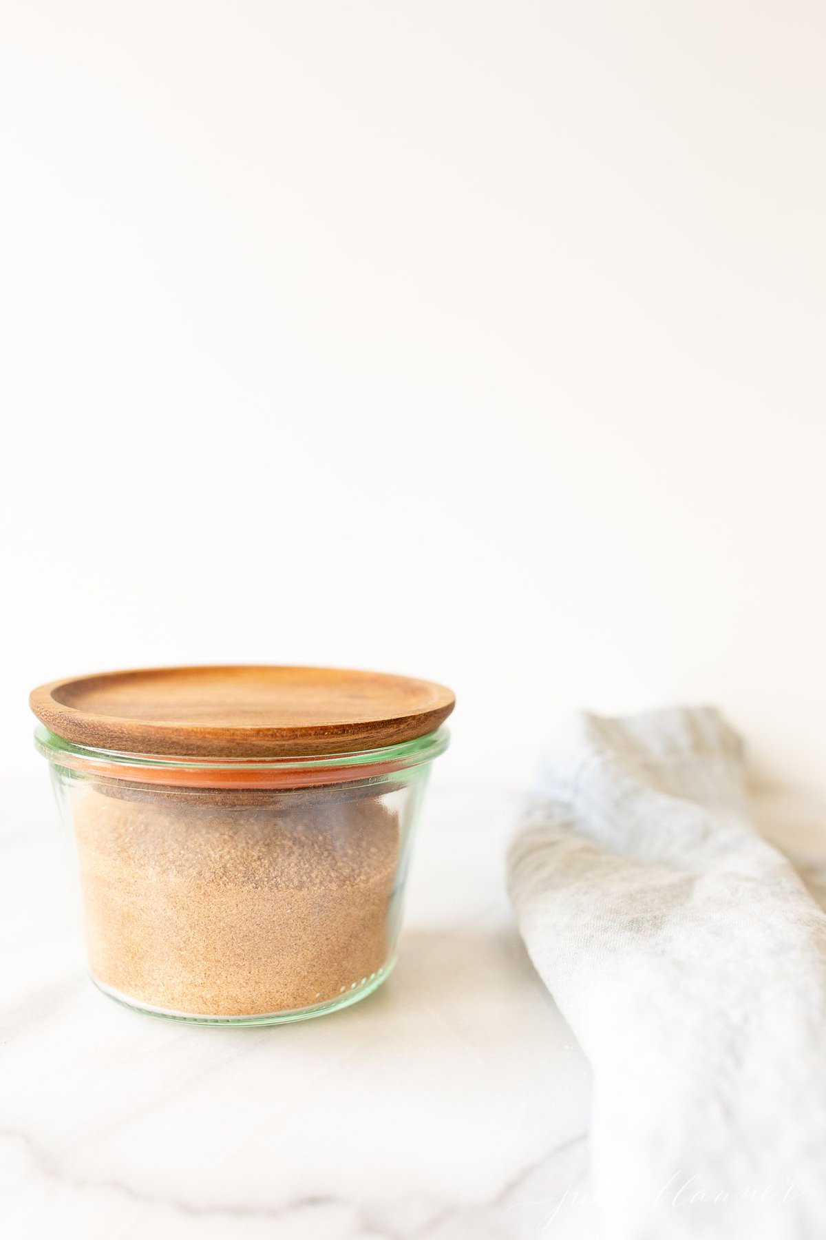 A glass jar of a cinnamon sugar recipe against a white background.