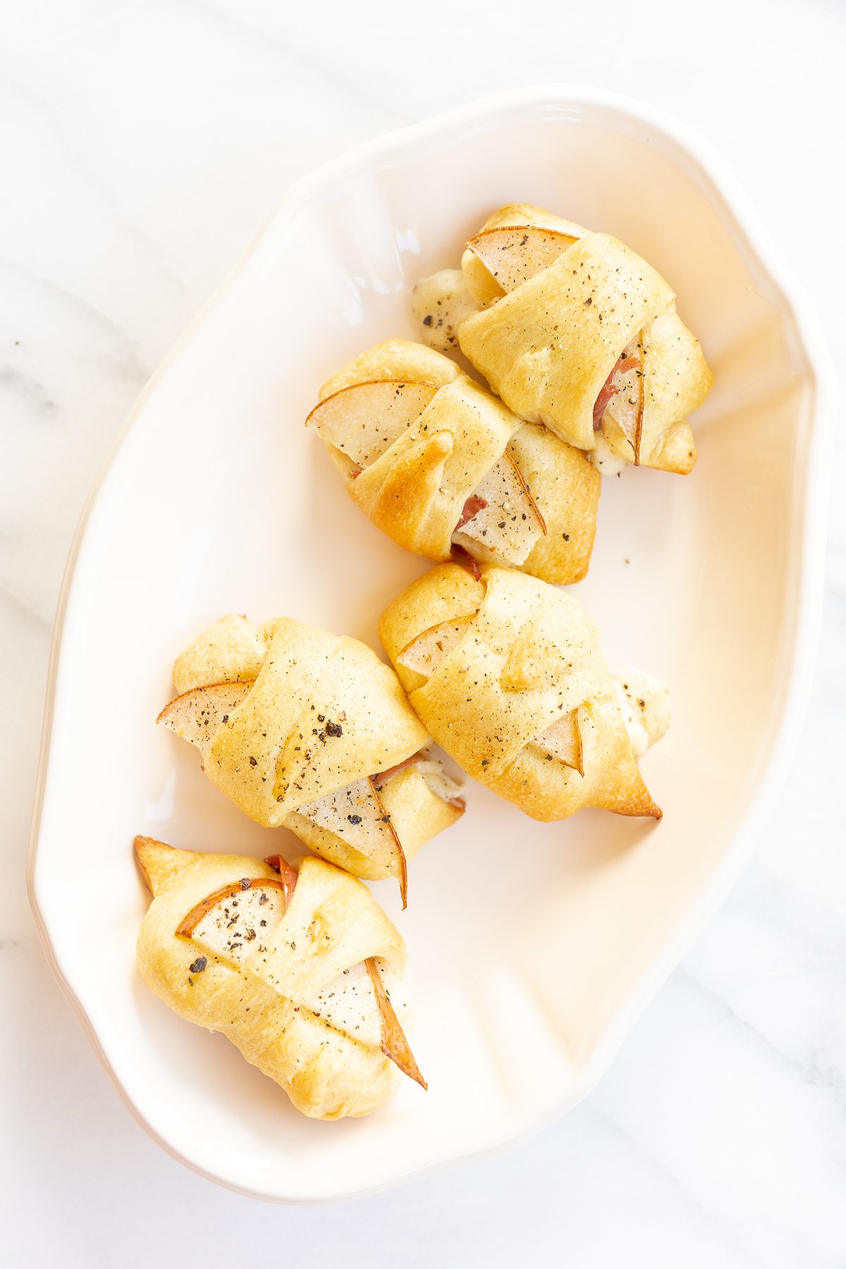 A white plate with a selection of Crescent Roll Appetizers on it.