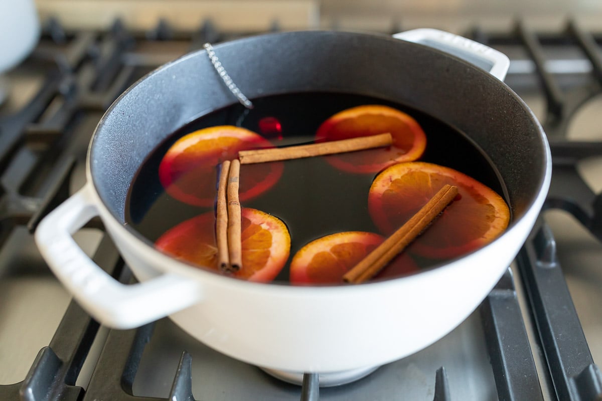 Mulled wine in a cast iron pot on a stovetop.