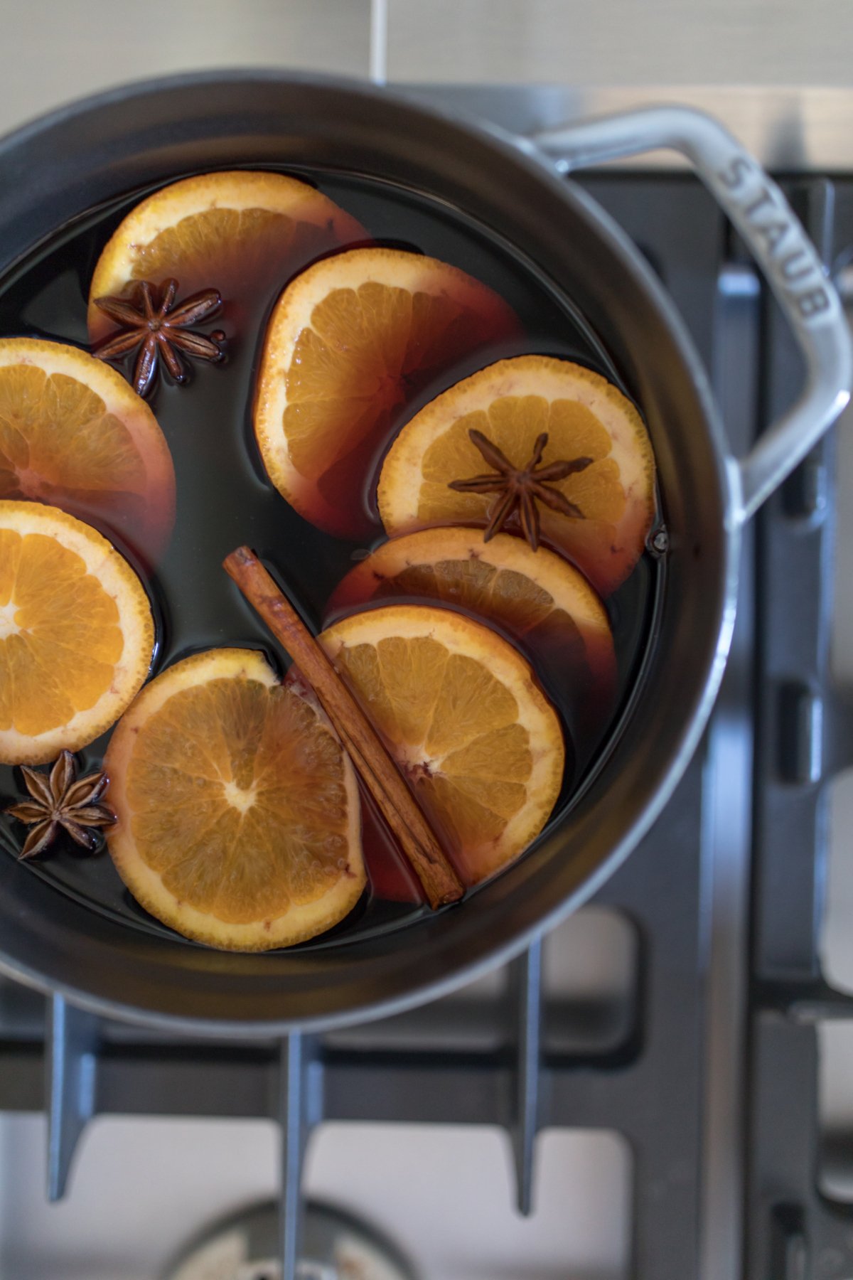 Mulled wine in a cast iron pot on a stovetop.