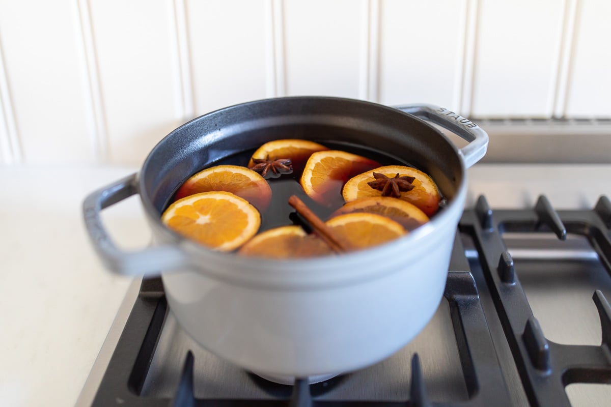 Mulled wine in a cast iron pot on a stovetop.