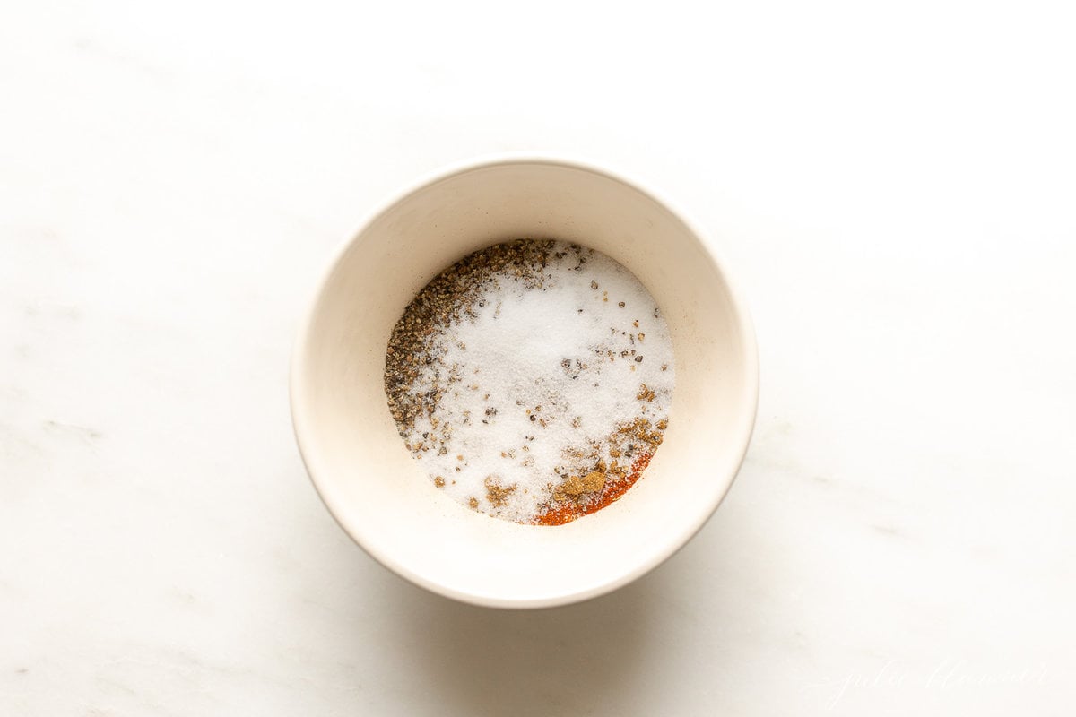 A small white bowl full of homemade taco seasoning ingredients.