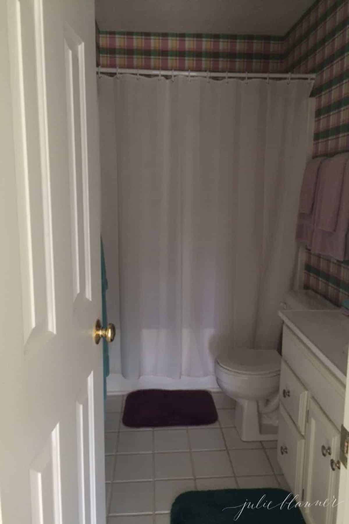 A nautical-themed bathroom with a toilet and shower curtain.