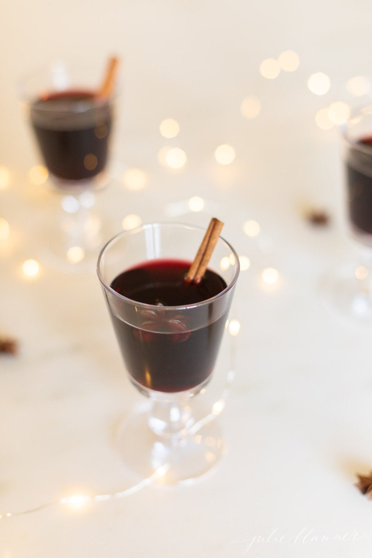 Glasses of mulled wine garnished with cinnamon sticks.