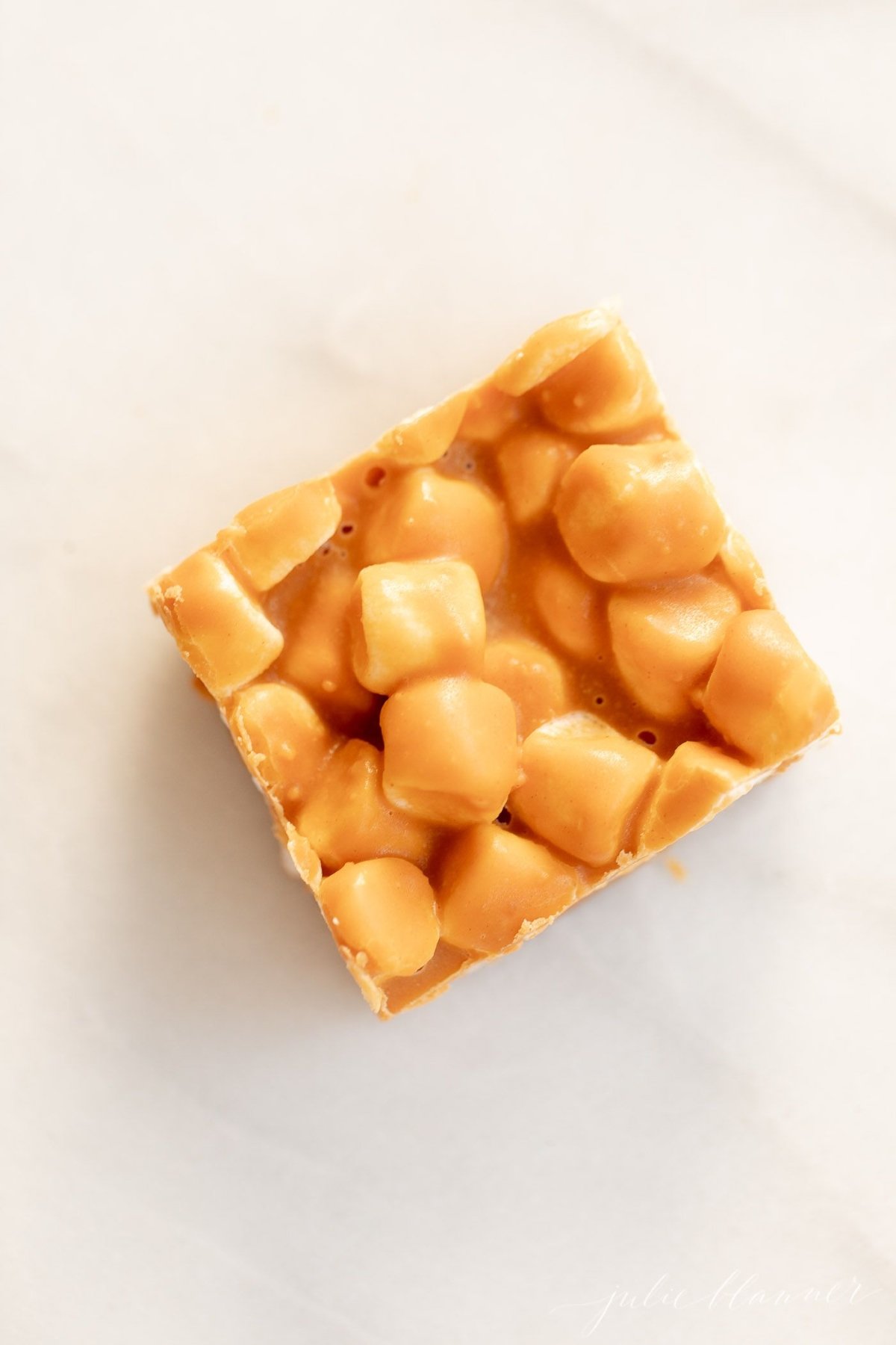 A butterscotch and marshmallow bar on a marble countertop.