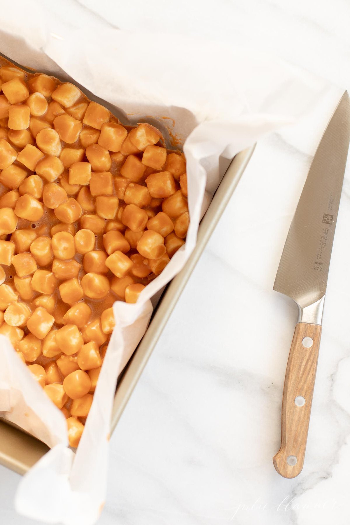 A gold cake pan full of butterscotch marshmallow bars