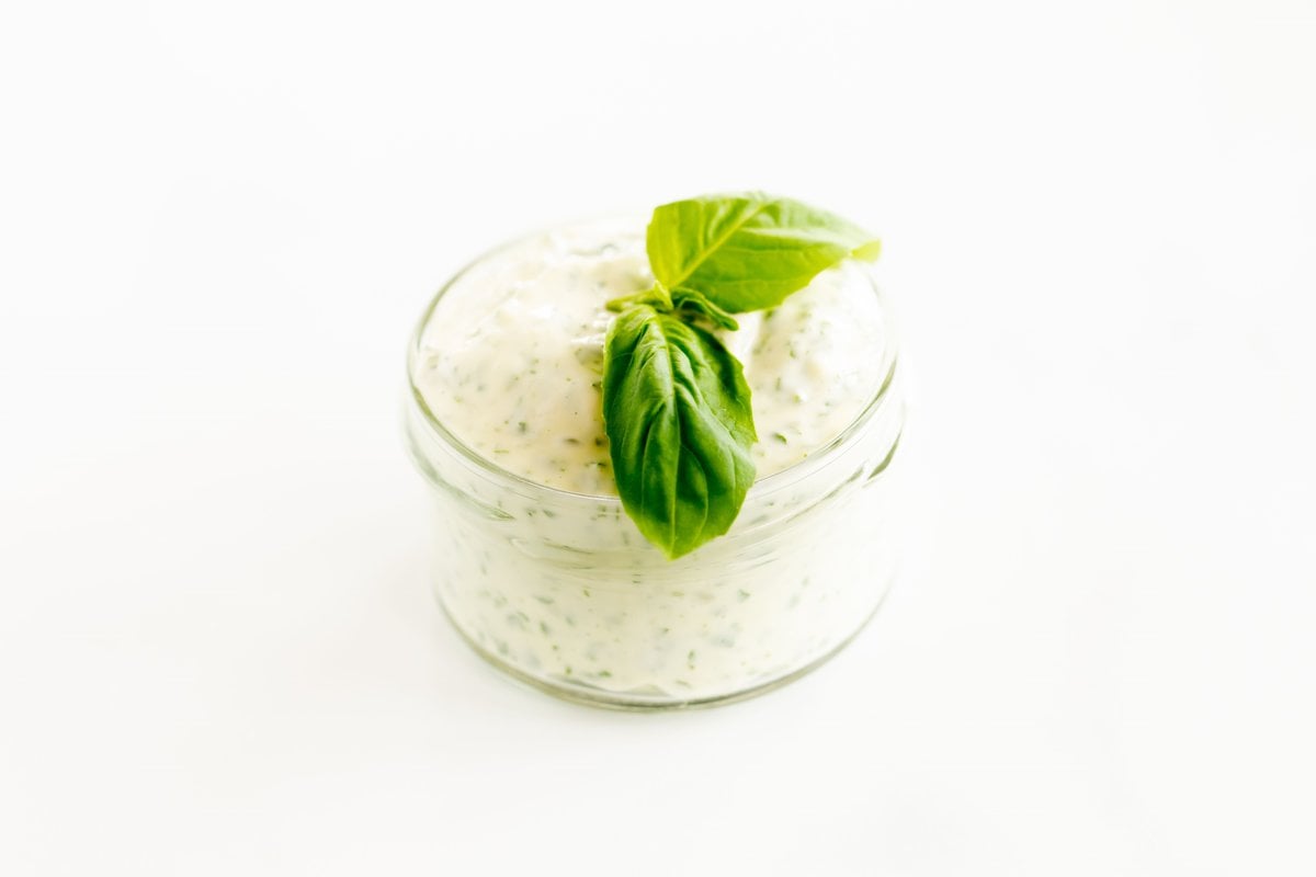 A small glass jar full of pesto aioli.