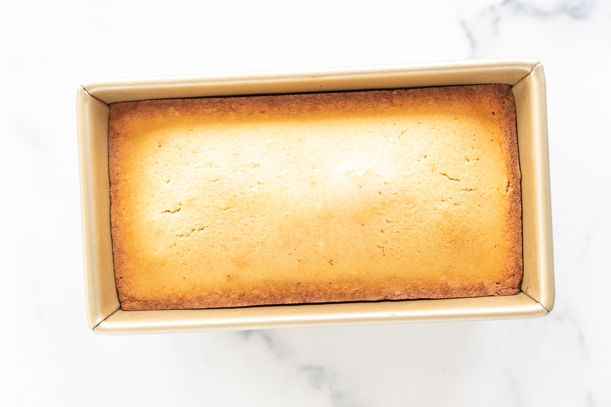 A loaf of pound cake in a box on a marble surface.