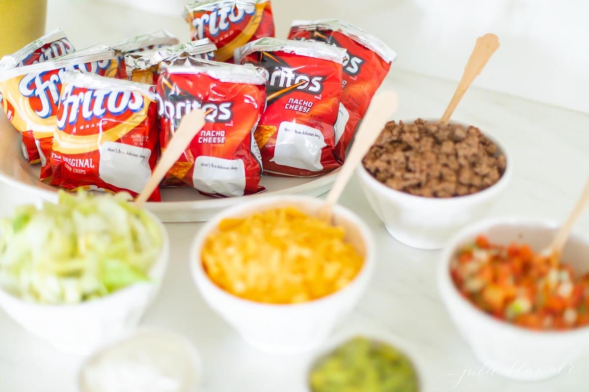 A walking taco bar set up with a green and blue painting in the background.