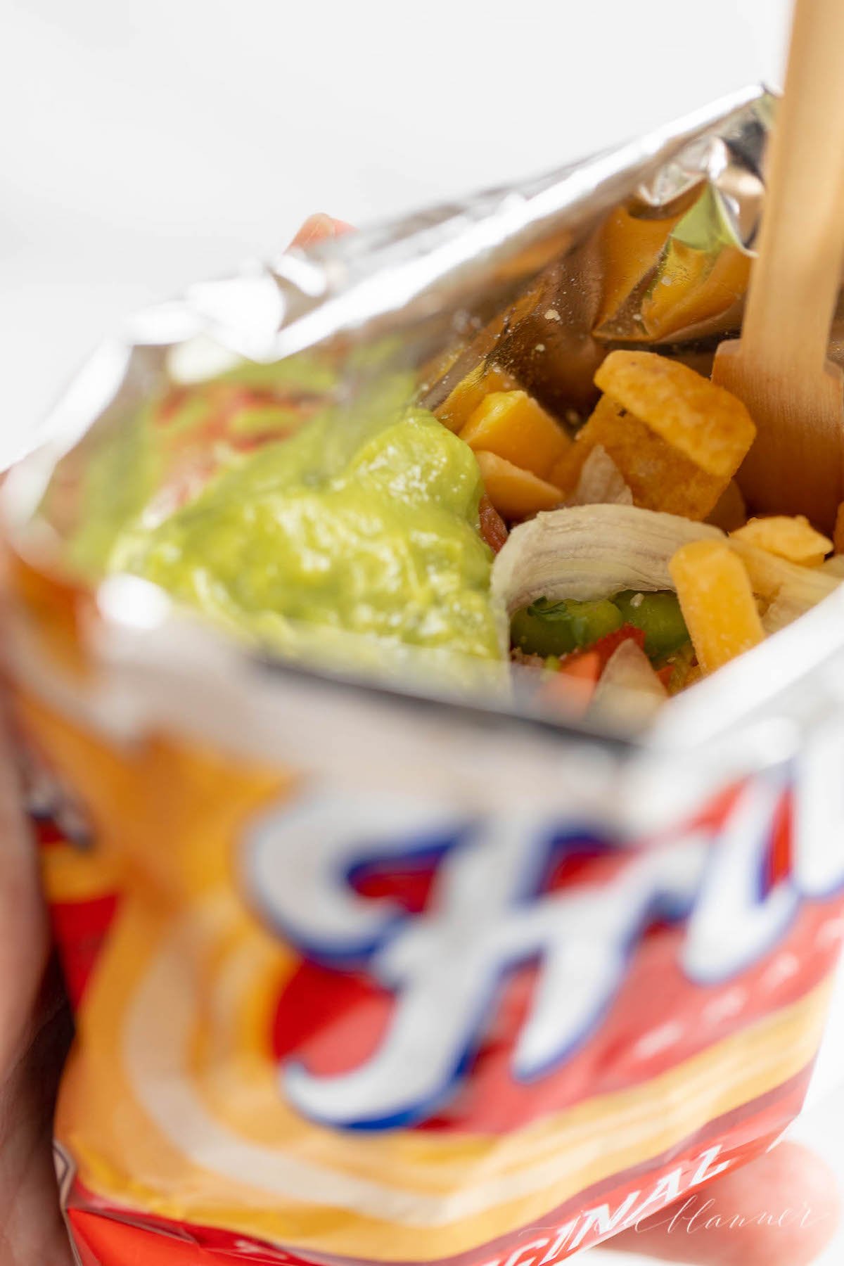 A Fritos bag of a walking tacos recipe with sour cream and guacamole.