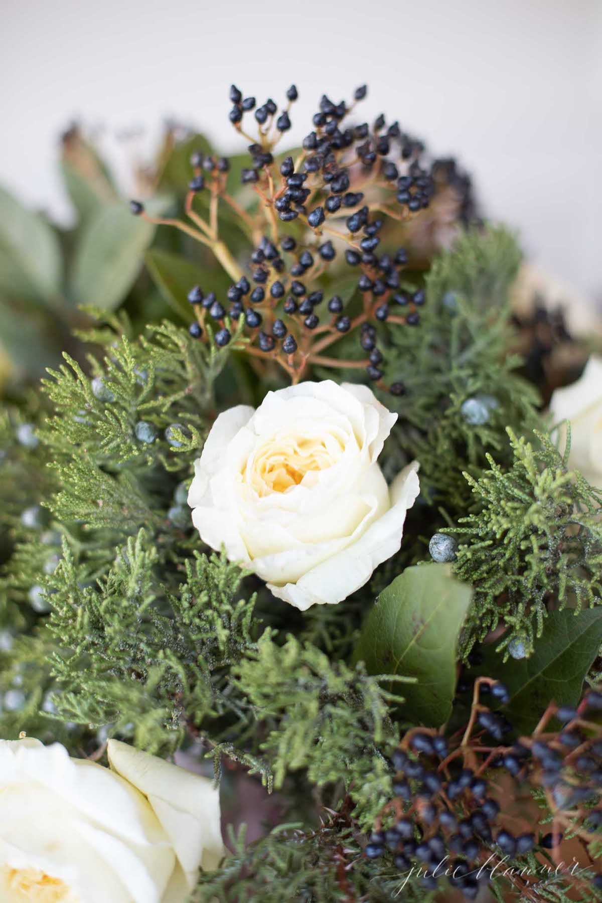 A bouquet of white roses and berries.