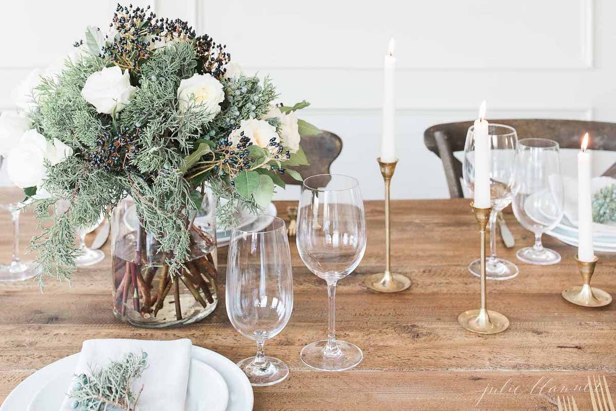 A table setting with white flowers and gold candlesticks.