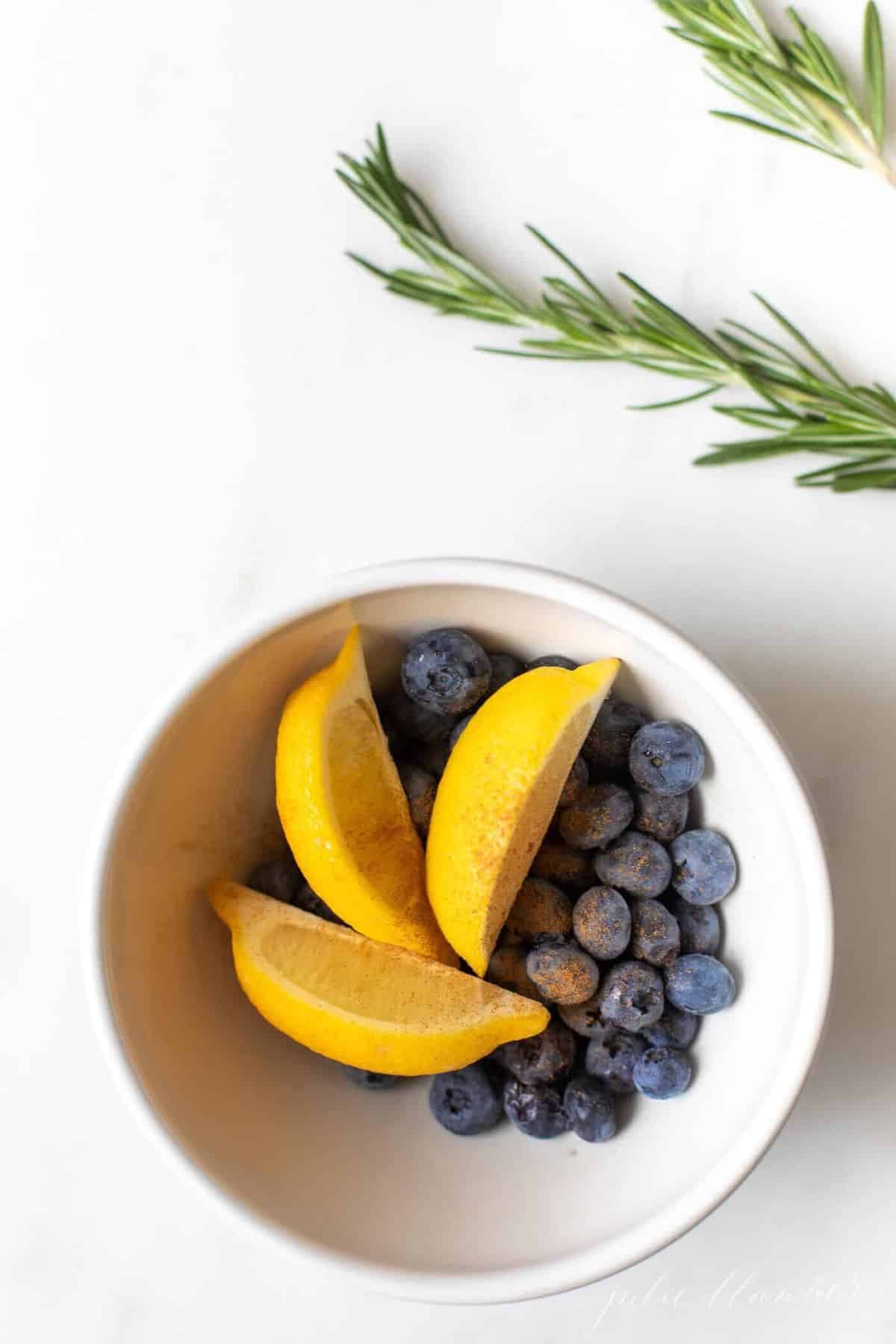 marble surface, bowl of lemon slices and blueberries..