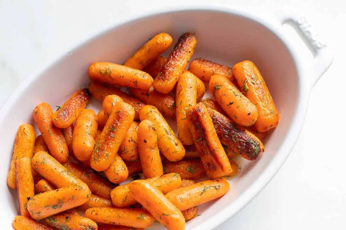 White oval serving platter with roasted dill carrots.