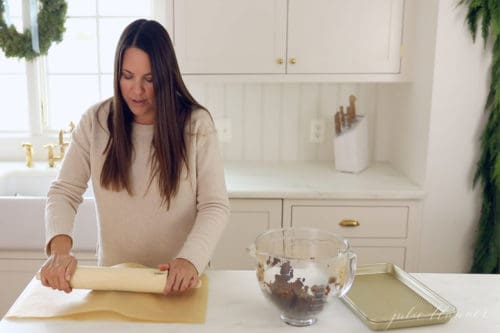 rolling cinnamon dough between parchment paper