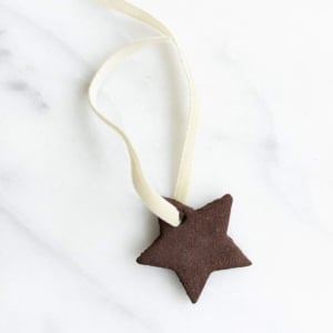 A single star handmade ornament on a marble surface.