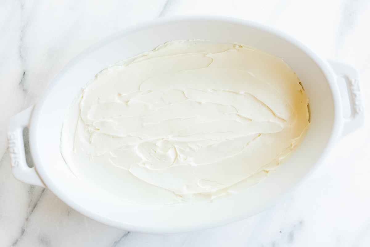 Easy appetizer dip in a white bowl on a marble countertop.