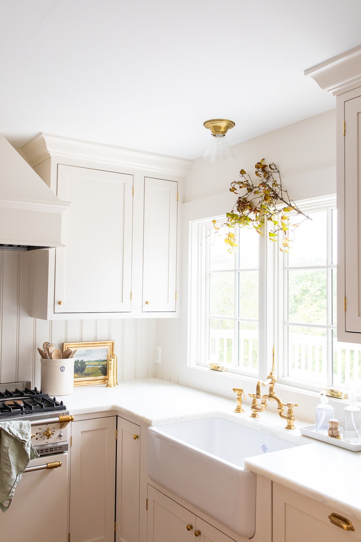 A traditional Thanksgiving menu being prepared in a white kitchen with a sink and a window.