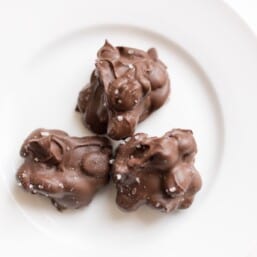 3 peanut clusters topped with sea salt on a white plate
