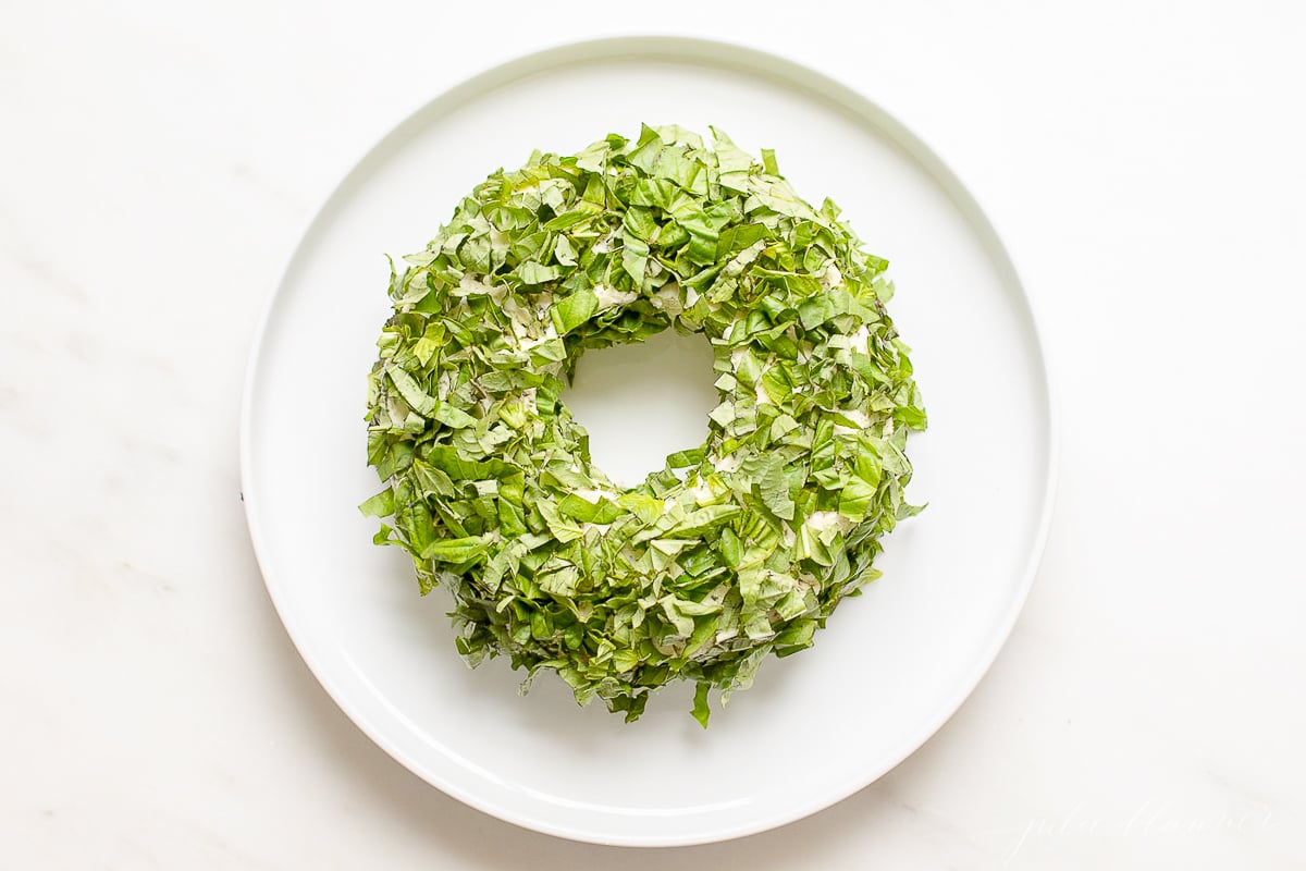 A basil covered pesto cheese ball wreath