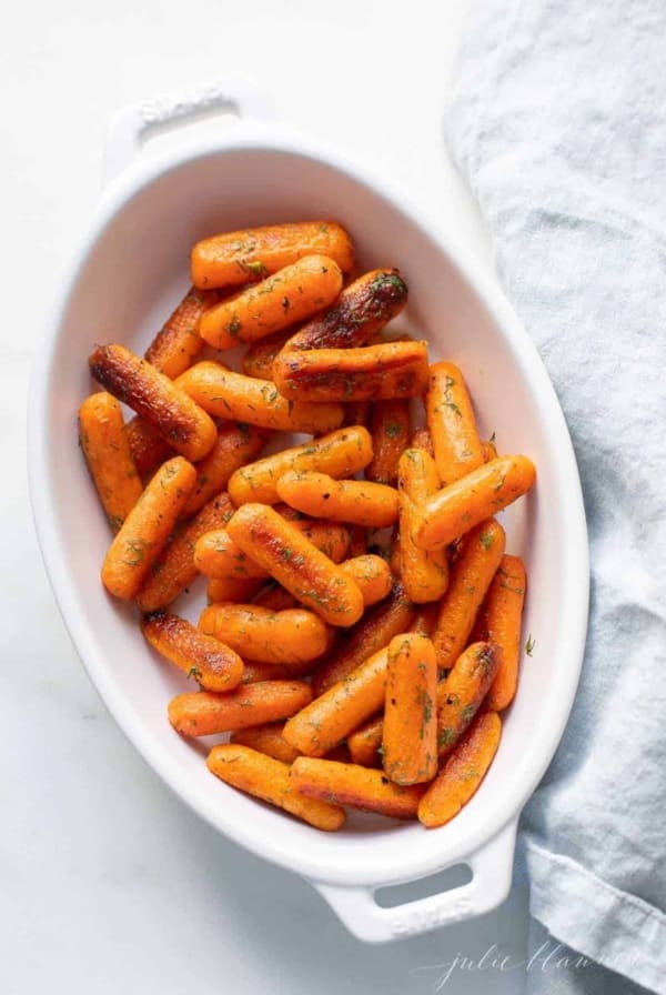 White oval serving platter with roasted dill carrots.