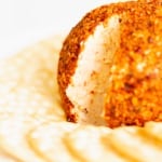 A cheeseball on a plate with crackers.