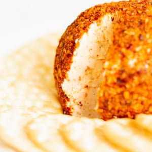 A cheeseball on a plate with crackers.