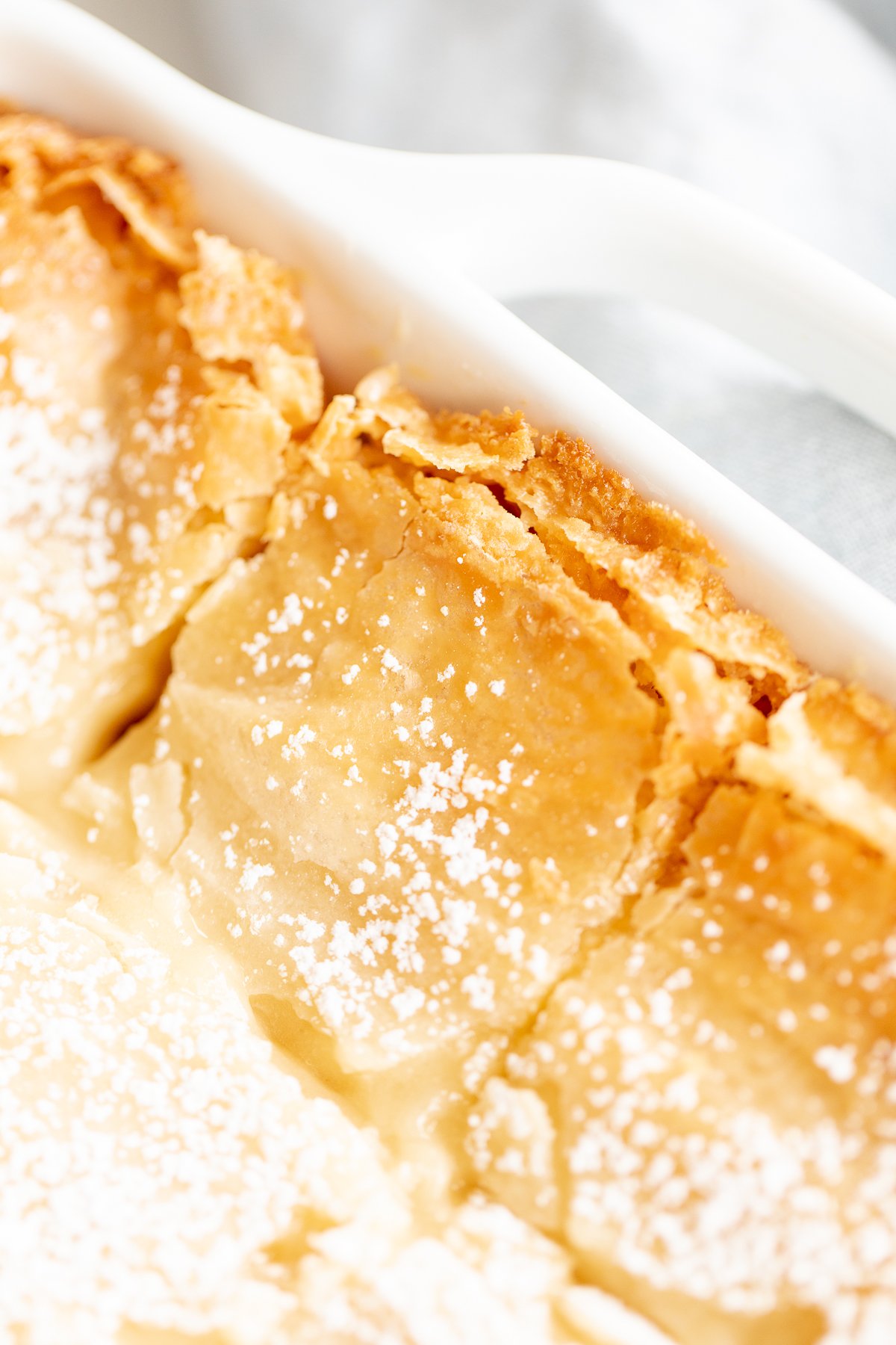 A white rectangular baking dish filled with a homemade gooey butter cake.