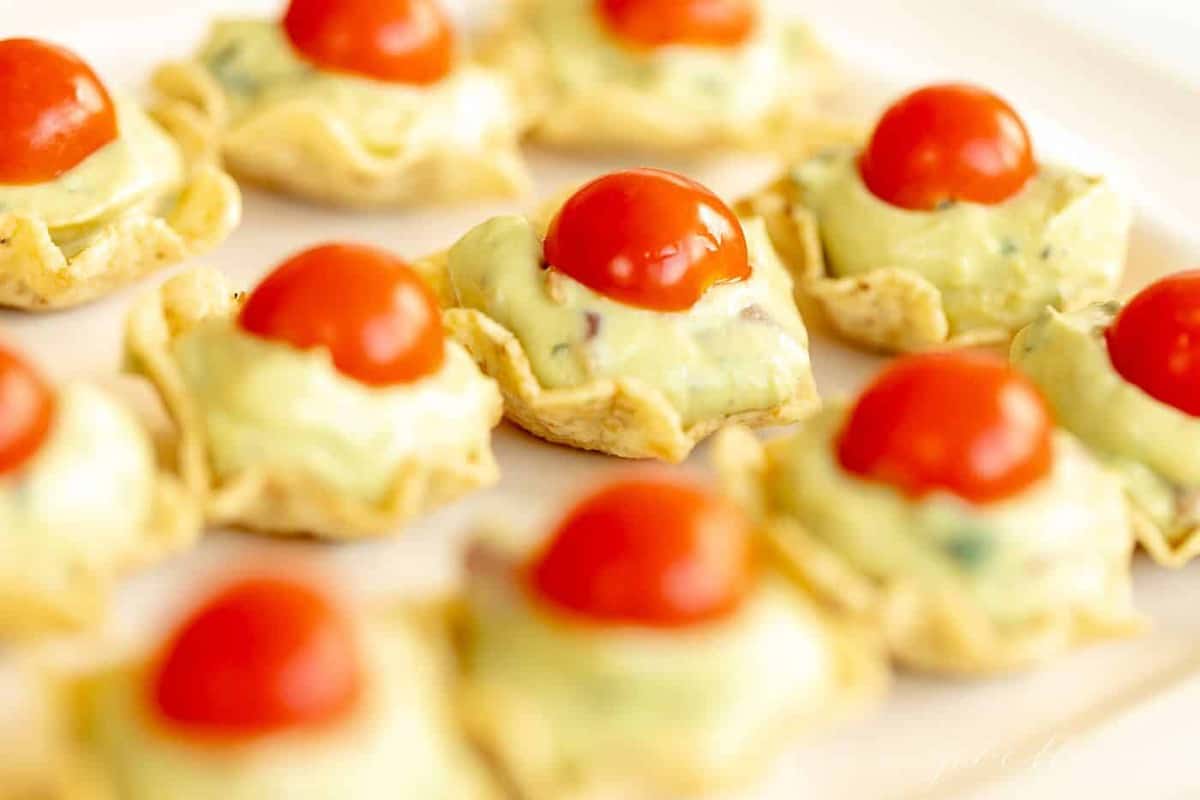 Guacamole bites on a white platter. 