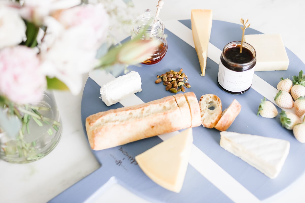 A blue cheeseboard with flowers in a hostess gift guide