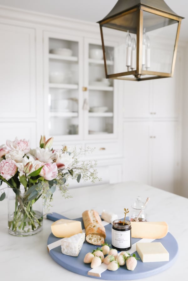 A blue cheeseboard with flowers in a hostess gift guide