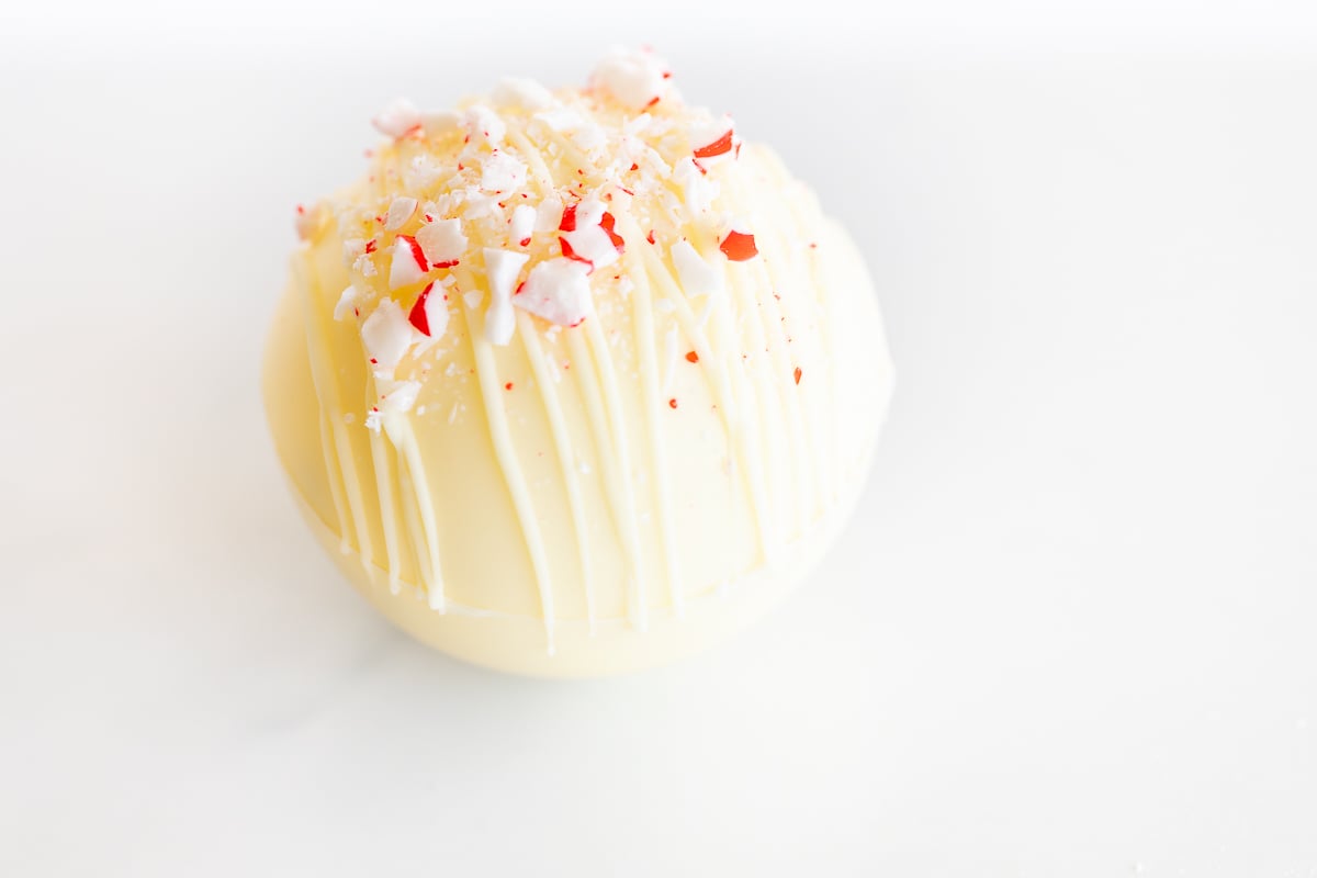 A white chocolate egg with peppermint sprinkles on top, perfect for peppermint desserts.