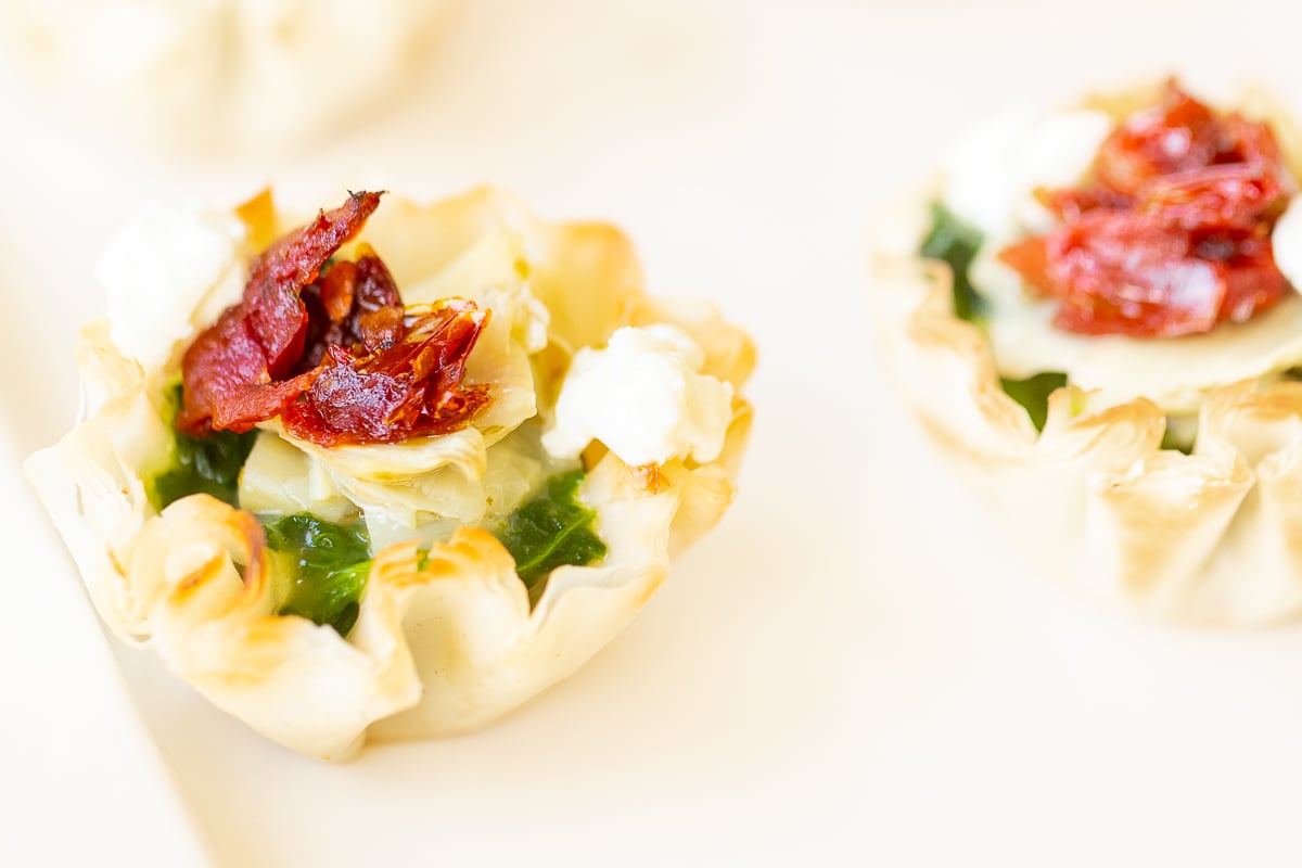 A plate of spinach dip cups on a white plate.