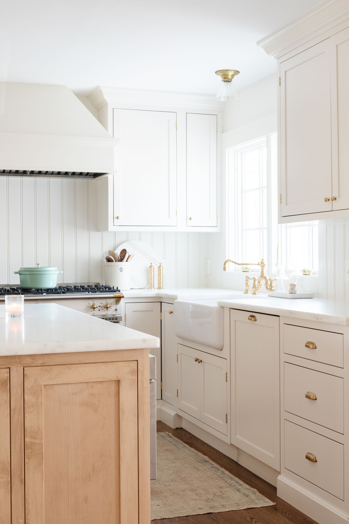 A cream kitchen with unlacquered brass hardware. 