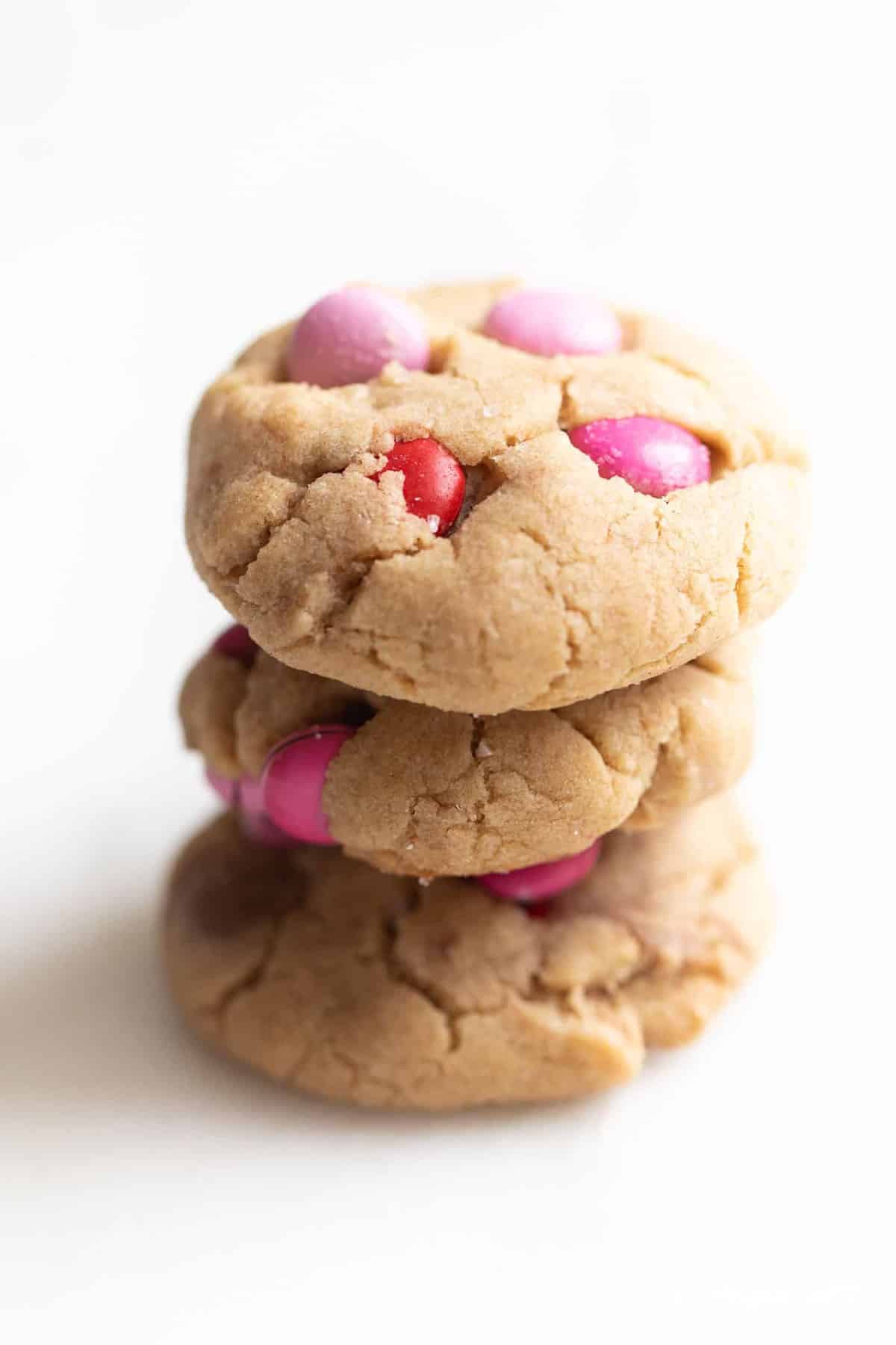 White surface, stack of three m&m cookies.