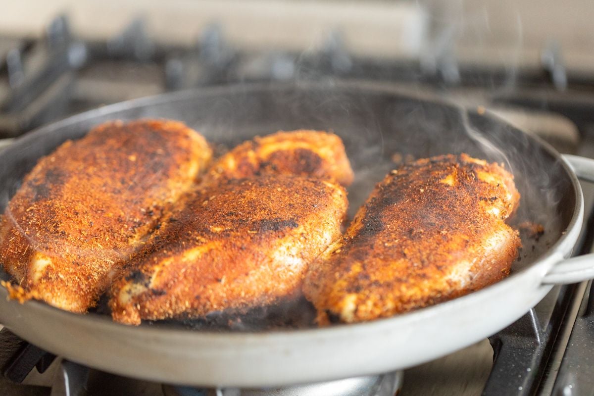 Blackened chicken breasts in a cast iron skillet