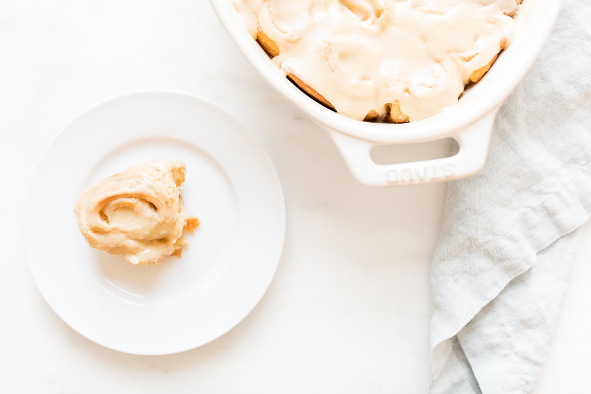 Caramel rolls in a white dish with icing.