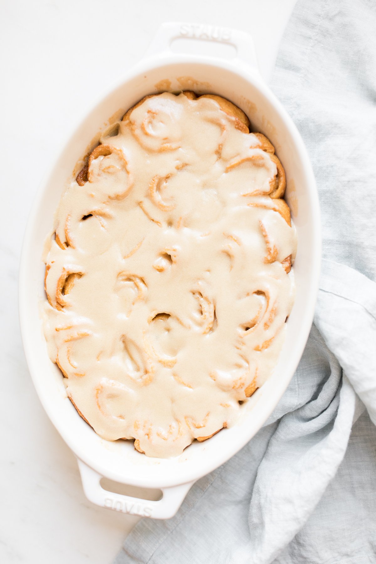 A white dish with caramel rolls.