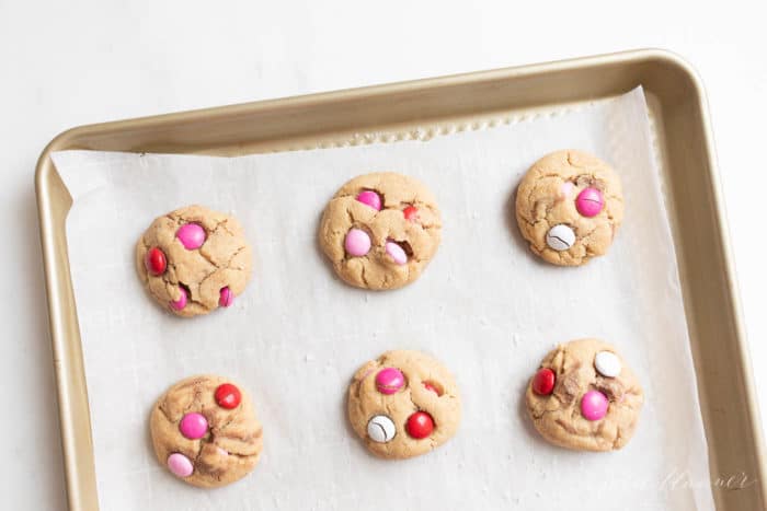 Gold baking sheet filled with Valentine's m and m cookies.